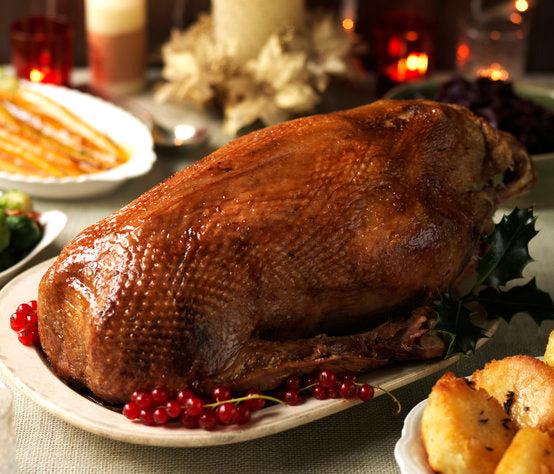 Cooked goose on a festive table setting with redcurrants